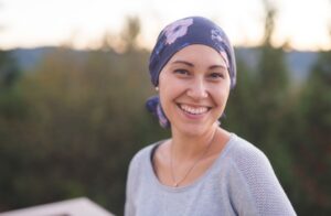 Woman outdoors smiles with purple scarf on her head