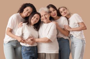 five women of different ages embrace